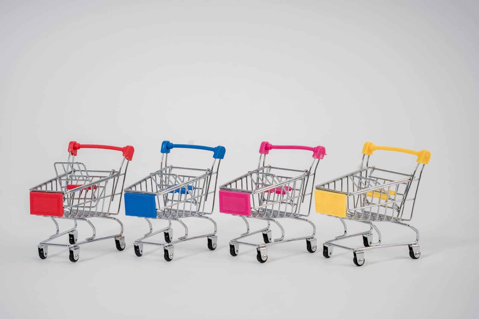 A narrow three-tier metal cart against a pale wall