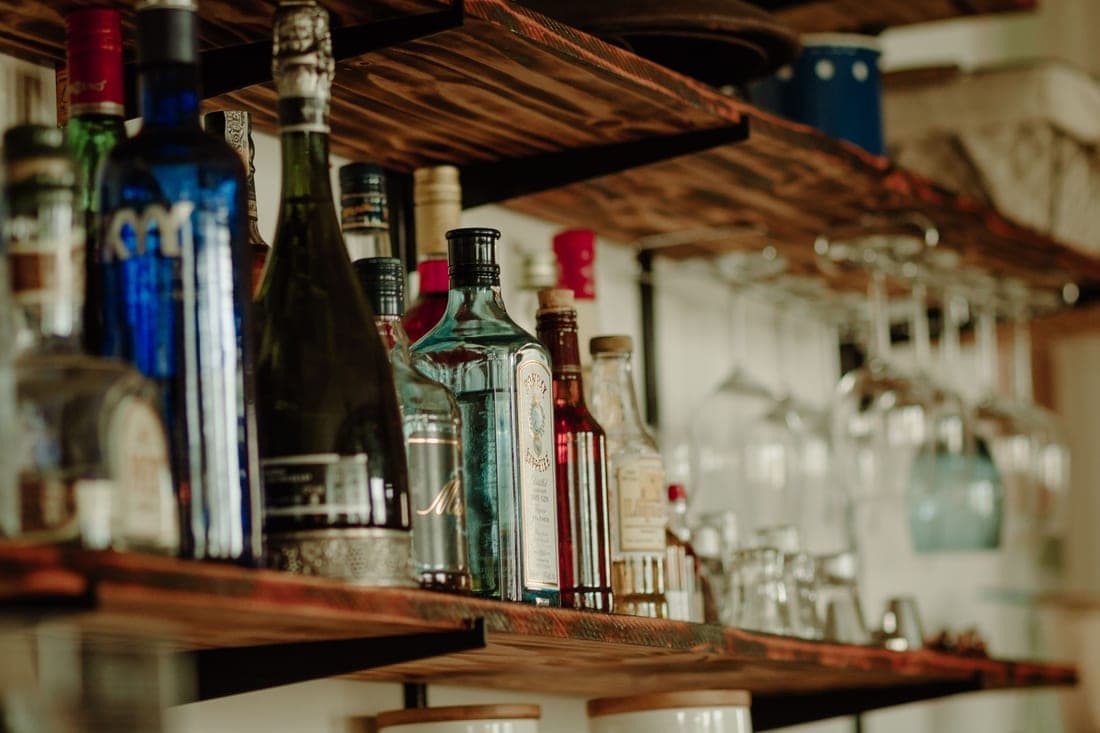 A two-tier rolling bar cart of this style, holding bottles and glassware