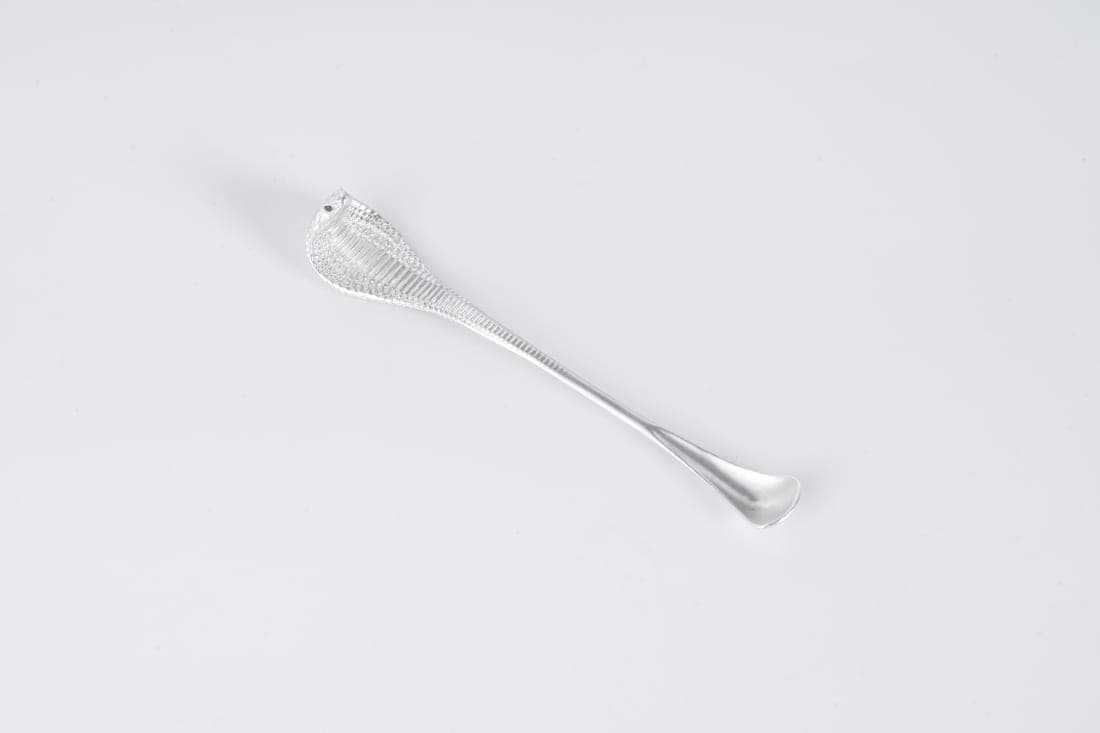 Twisted bar spoons laid beside a mixing glass