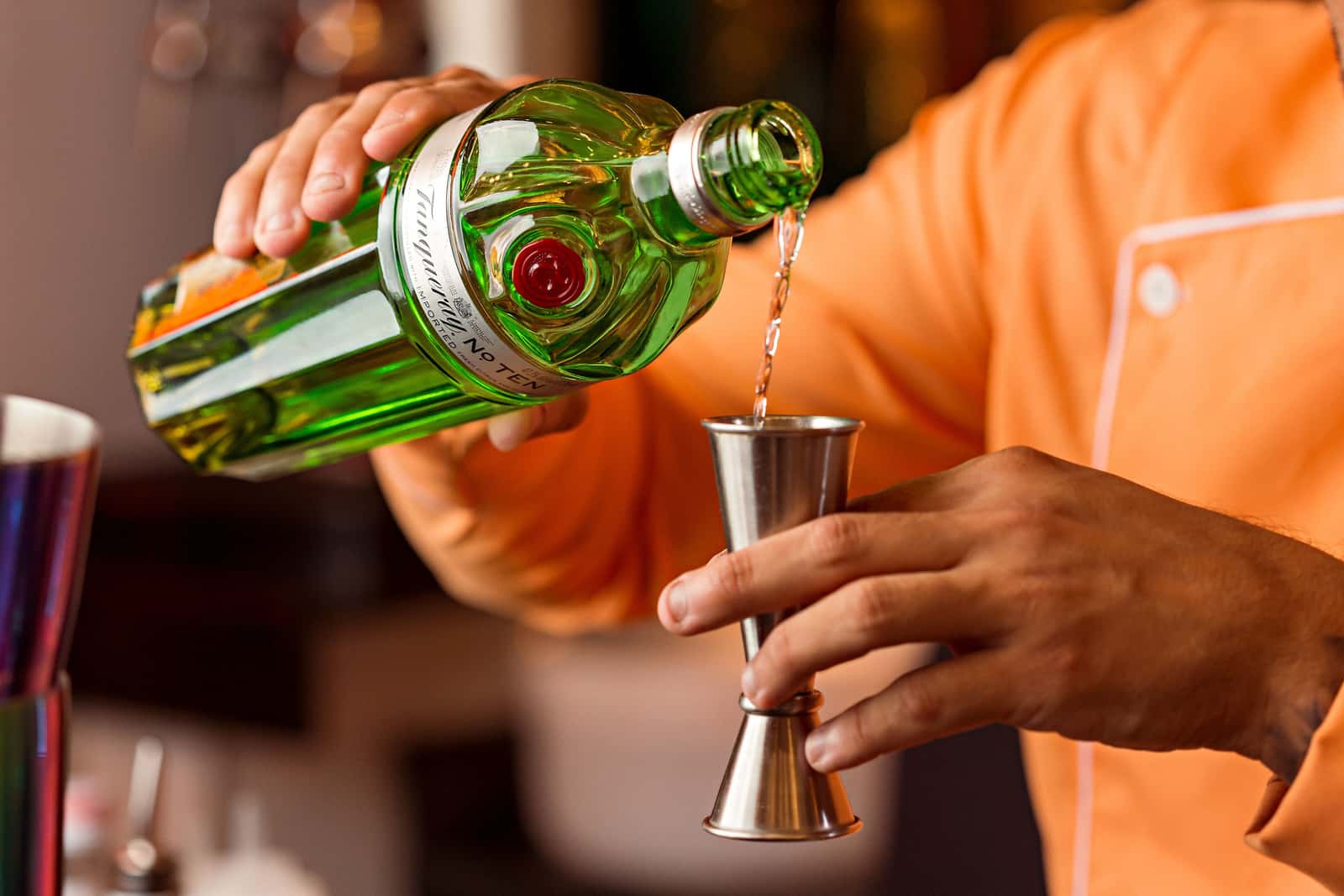 A tall Japanese style jigger being filled with spirit