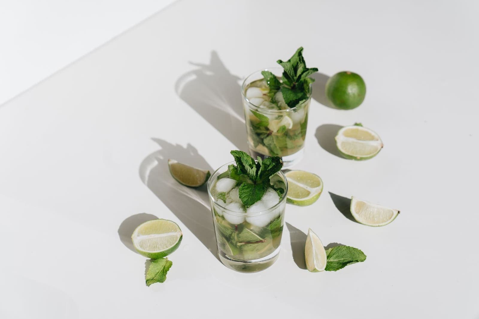 Glasses of mint and lime prepared for a muddled drink
