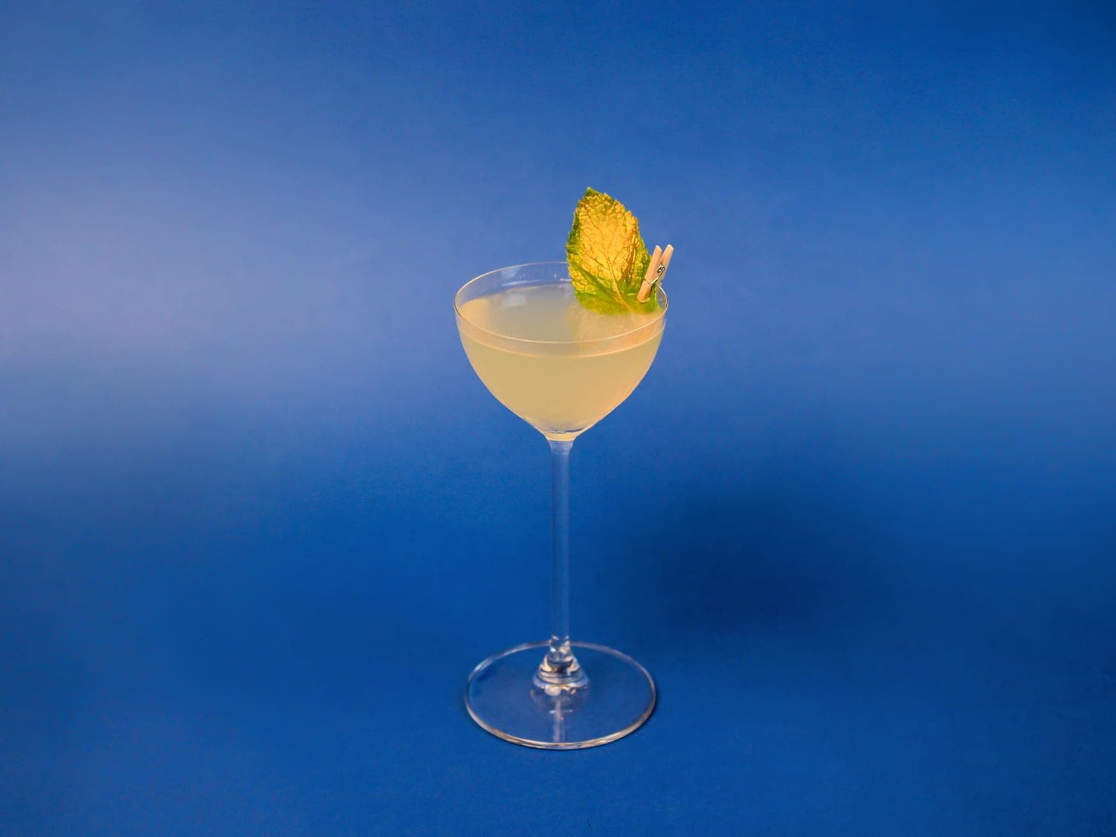 A small bell-shaped Nick and Nora glass with a stirred cocktail